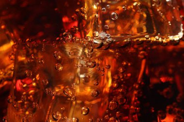 Arkaplan olarak buz küpleriyle kola tazeleniyor, makro görünüm