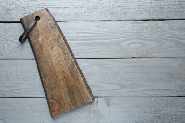 Gri ahşap masada bir tahta kesme tahtası, üst manzara. Metin için boşluk
