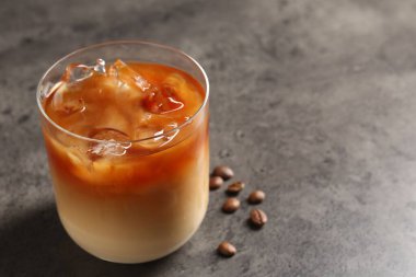 Gri masada lezzetli buzlu kahve ve fasulye, yakın plan. Metin için boşluk