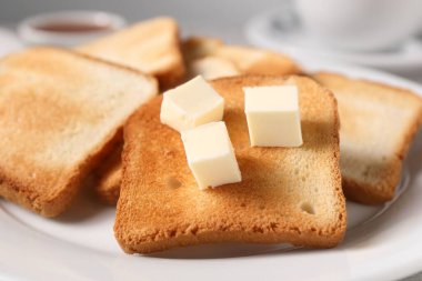 Lezzetli ekmek dilimleri, tabakta tereyağı, yakın plan.