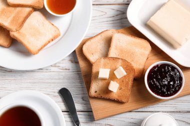 Lezzetli kızarmış ekmek dilimleri tereyağı ve reçel ile açık ahşap masa, düz yatar