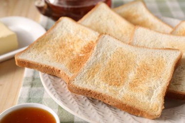 Lezzetli ekmek dilimleri ve ahşap masada reçel, yakın plan.