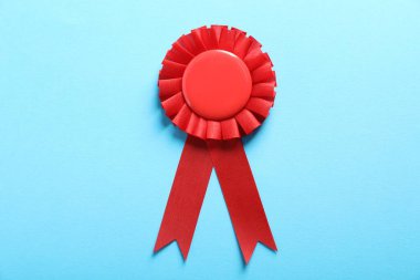 Açık mavi arkaplanda kırmızı ödül kurdelesi, üst görünüm