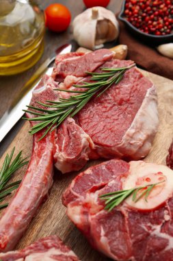 Ahşap masada çiğ et ve biberiye parçaları, yakın plan.
