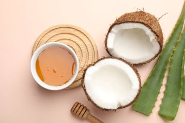 Saç tedavisi. Taze hindistan cevizi, bal ve aloe yaprakları bej arka planda, düz uzanmış