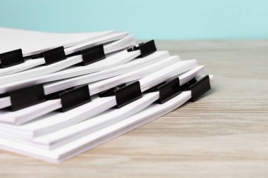 Tahta masadaki kağıtların olduğu ataçlar, yakın plan.