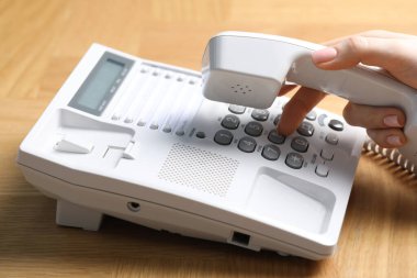 Ahşap masada telefonla arayan kadın, yakın plan.