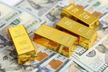 Parlak altın külçeler dolar banknotları, yakın plan