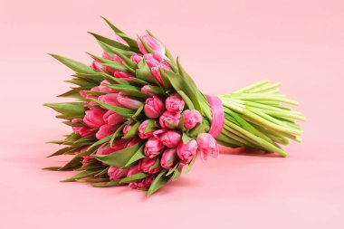 Bouquet of beautiful tulips on pink background