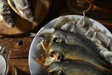 Kurutulmuş balık ve bira bardakları ahşap masada, düz yatıyordu.