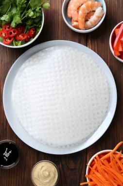 Yenebilir pirinç kağıtları ve malzemeler ahşap masada, düz yerde.