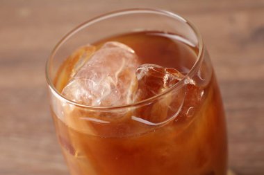 Ahşap masada lezzetli buzlu kahve, yakın plan.