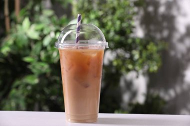 Beyaz masadaki buzlu kahve bulanık arka planda.