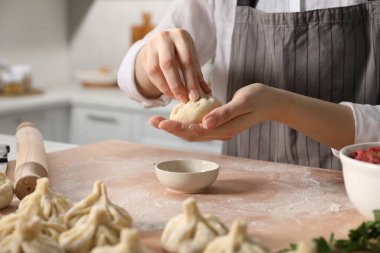Mutfaktaki masada khinkali yapan kadın, yakın plan.