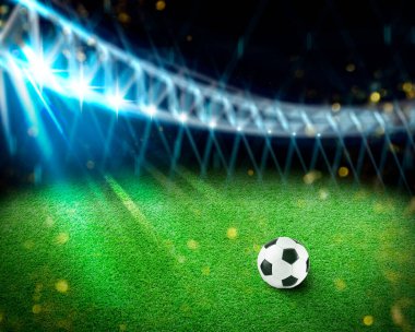 Futbol stadyumunda yeşil çimlerin üzerinde futbol topu, metin için alan