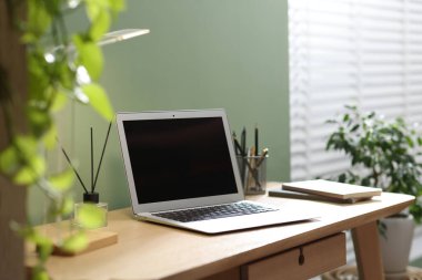 Merkez ofis. Oda odasındaki ahşap masada dizüstü bilgisayarı ve kırtasiyesi olan rahat bir iş yeri