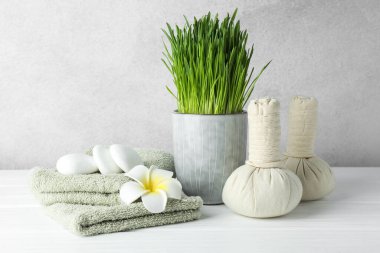 Açık gri arkaplana karşı beyaz masa üzerinde buğday çimi ile spa bileşimi