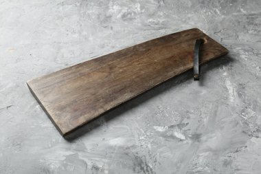 Açık gri desenli bir masada ahşap servis tahtası, yakın plan. Metin için boşluk