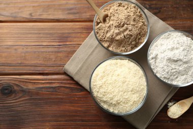 Tahta masadaki kaselerde farklı un türleri, üst manzara. Metin için boşluk