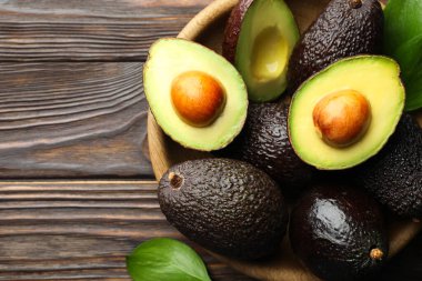 Avokado ve yaprakları ahşap masada, düz bir şekilde. Metin için boşluk