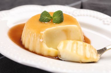 Karamel soslu lezzetli puding ve nane şekeri, yakın plan.