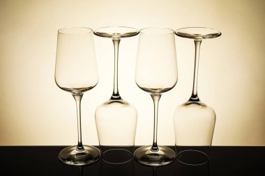 Ayna yüzeyinde bej arkaplana karşı birçok boş temiz bardak