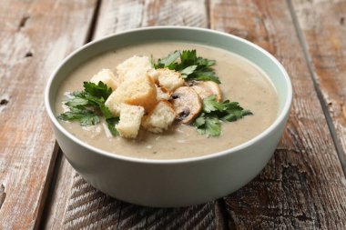 Ekmek arası mantar kremalı çorba ve ahşap masada maydanoz.