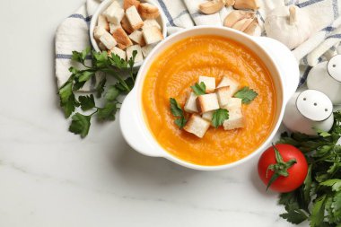 Beyaz mermer masadaki diğer ürünler arasında, kızarmış ekmek ve maydanozlu lezzetli balkabağı kreması çorbası. Metin için boşluk