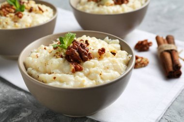 Cevizli lezzetli sütlaç, gri masada nane ve tarçın, yakın plan.