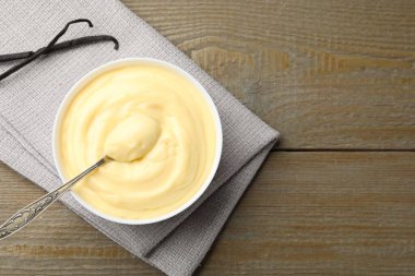 Lezzetli vanilyalı puding ve kapsüller ahşap masada, düz yerde. Metin için boşluk