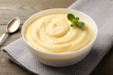 Tahta masada servis edilen naneli vanilyalı puding, yakın plan.