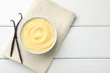 Lezzetli vanilyalı puding ve kapsüller beyaz ahşap masa, üst manzara. Metin için boşluk