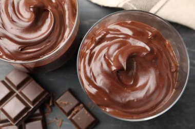 Lezzetli puding ve çikolata parçaları gri masada, düz yatıyordu.