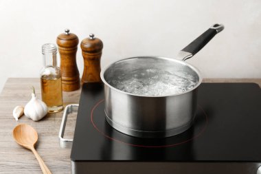 Kaynar su ile tencere ve ahşap masa üzerinde beyaz arka plan karşı soba