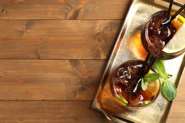 Küba libre kokteylini ahşap masa üzerinde nane şekeri ile tazeliyorum. Metin için boşluk