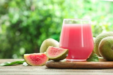 Guava suyunu tazeliyorum ve ahşap masada taze meyveler, yakın plan. Metin için boşluk