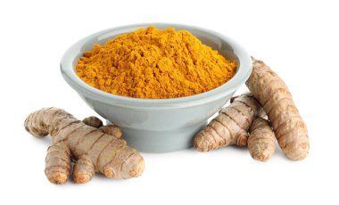 Kabın içindeki zerdeçal tozu ve beyaza izole edilmiş kökler