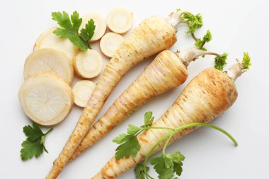 Parsley roots and leaves on white background, flat lay