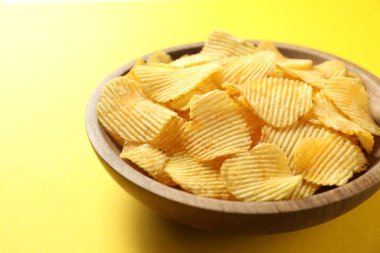 Sarı arka planda patates cipsi, yakın plan.