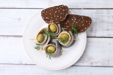 Lezzetli ringa dürümleri zeytin, dereotu ve ekmek beyaz ahşap masa, üst manzara