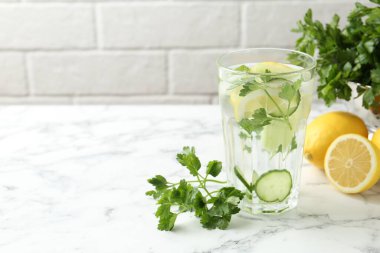 Maydanozlu sağlıklı içecek, salatalık ve limonlu beyaz mermer masa, metin için yer