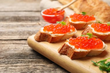 Kırmızı havyarlı sandviçler ve ahşap masada mikroyeşiller, yakın plan.