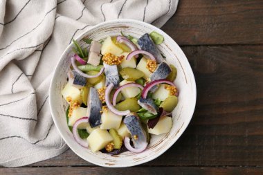 Ringa balıklı lezzetli salata, sebzeler ve ahşap masada hardal, üst manzara.