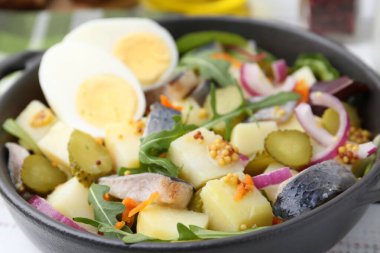 Ringa balıklı lezzetli salata, yumurta ve sebzeler masada, yakın plan.