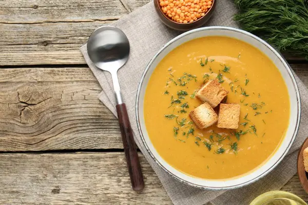 Tahta masada servis edilen leziz mercimek kremalı çorba.