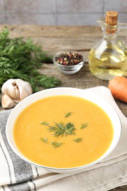 Ahşap masada servis edilen dereotlu mercimek kremalı leziz çorba.