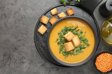 Gri masadaki kızarmış ekmeklerle servis edilen leziz mercimek kremalı çorba. Metin için boşluk