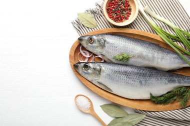 Tuzlu ringa balıkları ve baharatlar beyaz ahşap masada, düz yerde. Metin için boşluk