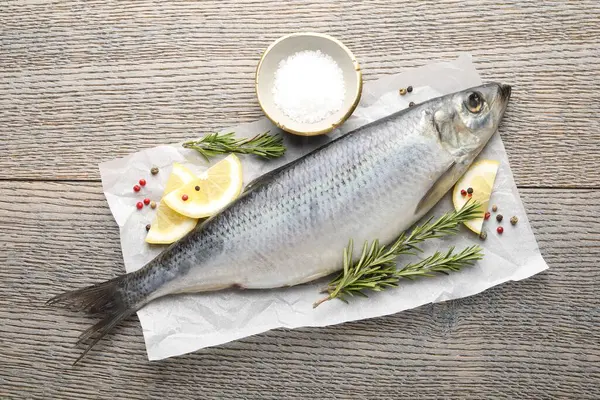 Tuzlu ringa balığı ve baharatlar ahşap masada, düz yatıyordu.