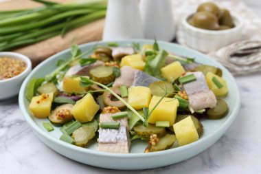 Ringa balıklı lezzetli salata ve beyaz mermer masada malzemeler, yakın plan.